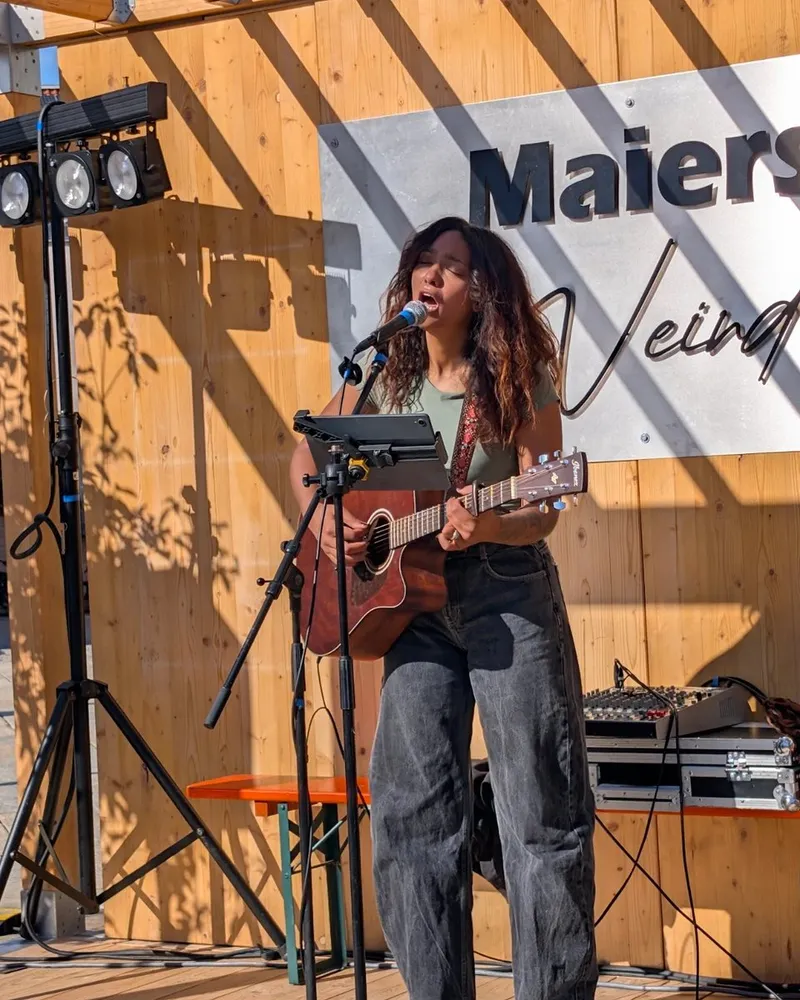 Singer-Songwriterin Lateesha Halmen mit Akustikgitarre am Mikrofon auf der Bühne am Schlossplatz